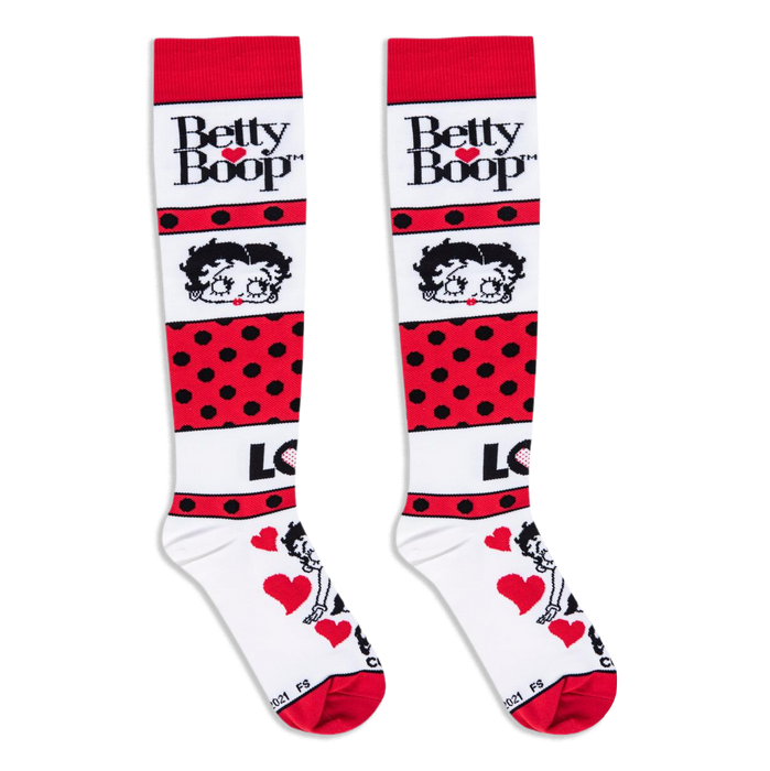 Flat lay of white and red knee-high socks showing the Betty Boop logo, her face, polka dots, and a love graphic.