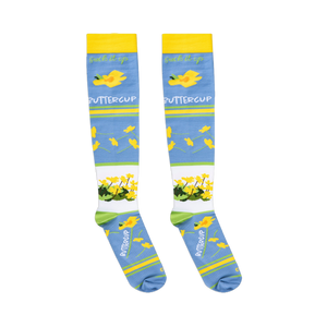 Flat lay of light blue socks showing the cursive suck it up text above scattered yellow buttercups.