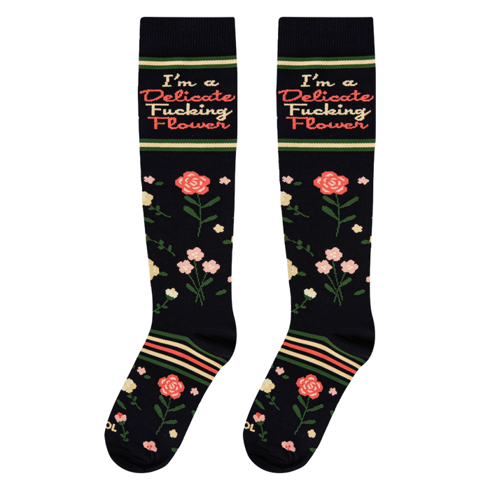 Flat lay view of black knee-high socks showing the full floral pattern and the I'm a Delicate Fucking Flower text.
