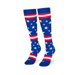 Blue knee-high socks standing upright, featuring white stars and red and white stripes across the leg and foot area.