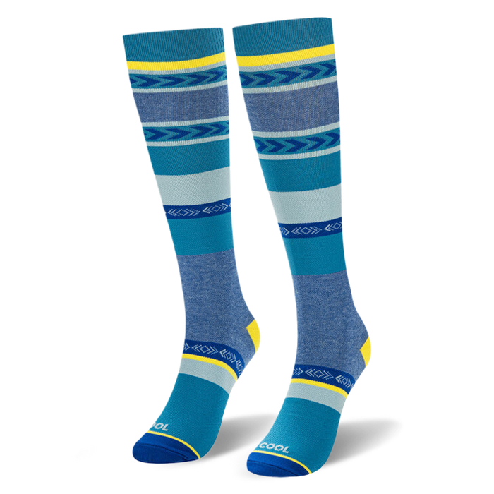 Angled studio shot of blue geometric striped knee-high socks highlighting the bright yellow heel and COOL toe text.