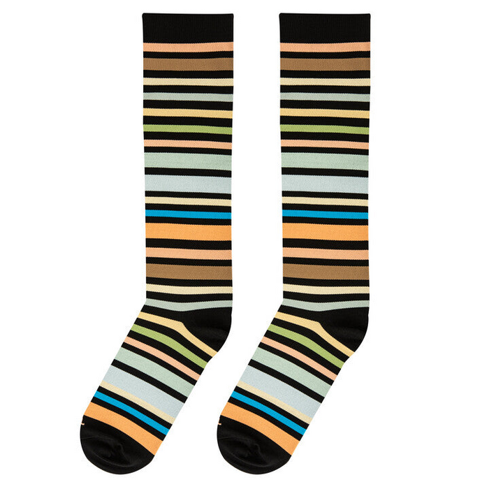 Flat lay of two knee-high socks side-by-side, displaying varied horizontal stripes in brown, green, blue, and peach.
