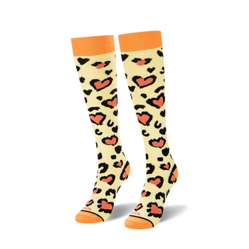 Pair of pastel yellow knee-high socks with a leopard print and coral hearts.  Orange top cuffs.