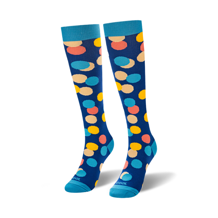 Pair of knee-high socks in blue with multicolored polka dots.  The dots are in shades of yellow, orange, and pink.