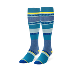 Knee-high socks featuring wide teal, navy, and heather blue stripes mixed with geometric arrow patterns and yellow accents.