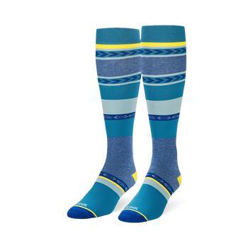 Knee-high socks featuring wide teal, navy, and heather blue stripes mixed with geometric arrow patterns and yellow accents.