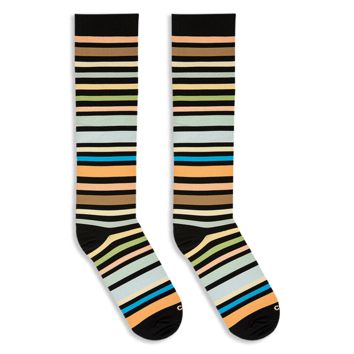 Angled flat lay of two knee-high striped socks with black cuffs and toes, featuring a mix of earth tones and bright teal.