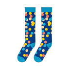 Flat lay of two long navy blue socks with large colorful polka dots side by side, showing the light blue cuffs and toes.