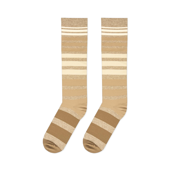Flat lay view of knee-high socks with gradient brown and cream horizontal stripes against a black background.