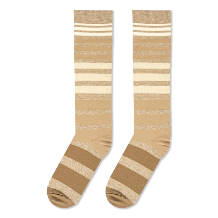 Flat lay view of knee-high socks with gradient brown and cream horizontal stripes against a black background.