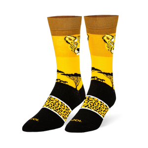 Yellow crew socks with a cheetah face, black savanna tree silhouette, and a black foot featuring a spotted yellow band.