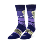 Dark blue and purple crew socks featuring an elephant head, black savanna silhouettes, and a beige wrinkled skin pattern.