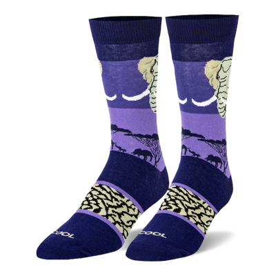 Dark blue and purple crew socks featuring an elephant head, black savanna silhouettes, and a beige wrinkled skin pattern.