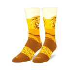 Pair of crew socks, gold and brown, featuring a majestic lion's face and a savanna landscape.