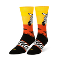 Black crew socks featuring a yellow and orange sunset, zebra head portrait, safari tree silhouettes, and an arch stripe band.