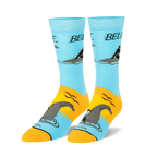 Pair of crew socks, light blue and orange, featuring a graphic of a man riding a Loch Ness Monster and the word 'BELIEVE'.
