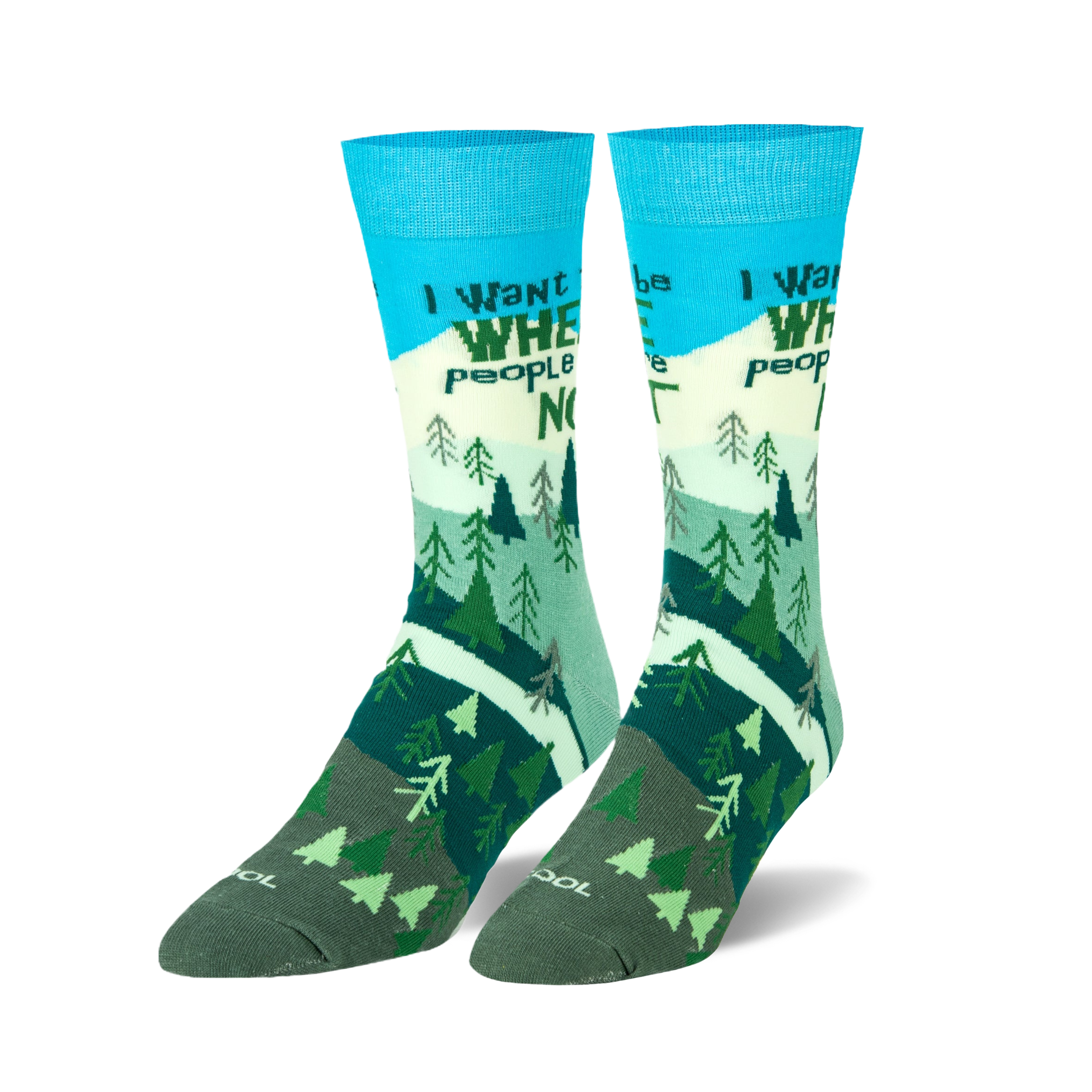 Pair of crew socks; teal, green, and white; features a mountain scene with trees and the phrase 'I want to be where people are not'.