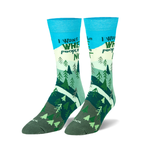 Pair of crew socks; teal, green, and white; features a mountain scene with trees and the phrase 'I want to be where people are not'.