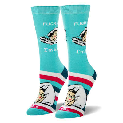 Aqua crew socks showing a retro sleeping woman with text FUCK OFF I'm busy, plus pink, white, navy, and teal foot stripes.