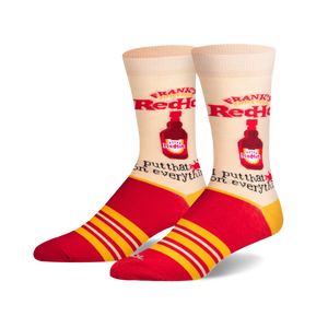 A pair of cream crew socks with red and yellow stripes. The socks feature a repeating image of Frank's RedHot sauce bottle and the phrase 'I put that on everything'.