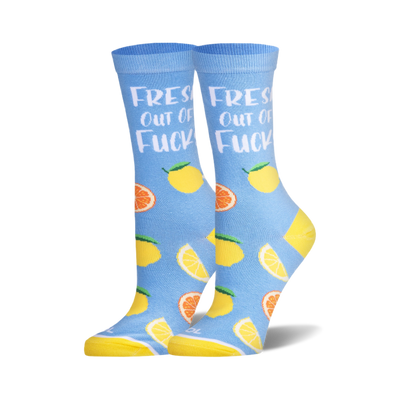 Pair of crew socks in light blue with yellow heels and toes. Features lemons, orange slices, and "Fresh Out of Fucks" text.