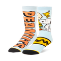 Light blue split crew socks. One has large orange Peanuts text, the other shows Snoopy, Woodstock, and a yellow zigzag.