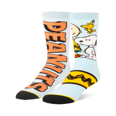 Light blue split crew socks. One has large orange Peanuts text, the other shows Snoopy, Woodstock, and a yellow zigzag.