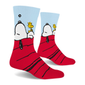 Side view of crew socks showing Snoopy's head and black ear hanging off the red roof while Woodstock sits on his stomach.