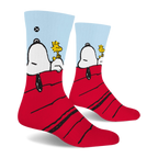 Side view of crew socks showing Snoopy's head and black ear hanging off the red roof while Woodstock sits on his stomach.