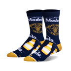 Pair of crew socks in navy blue, featuring Modelo beer bottle and logo graphics in yellow and white.