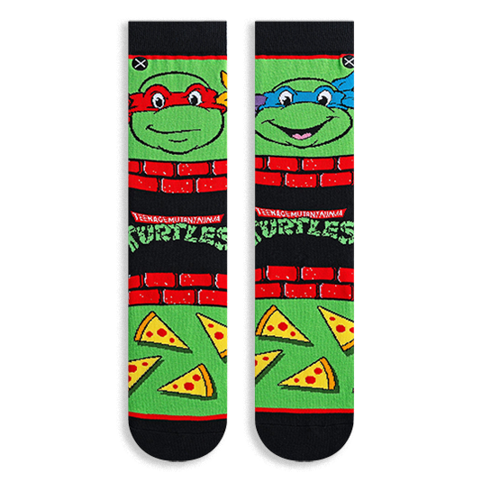 Flat lay of two TMNT socks showing Raphael in red on the left and Leonardo in blue on the right, with pizza slices below.