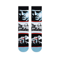 Flat lay of Godfather crew socks displaying a blue character portrait, The Godfather logo, and playing cards with a skyline.