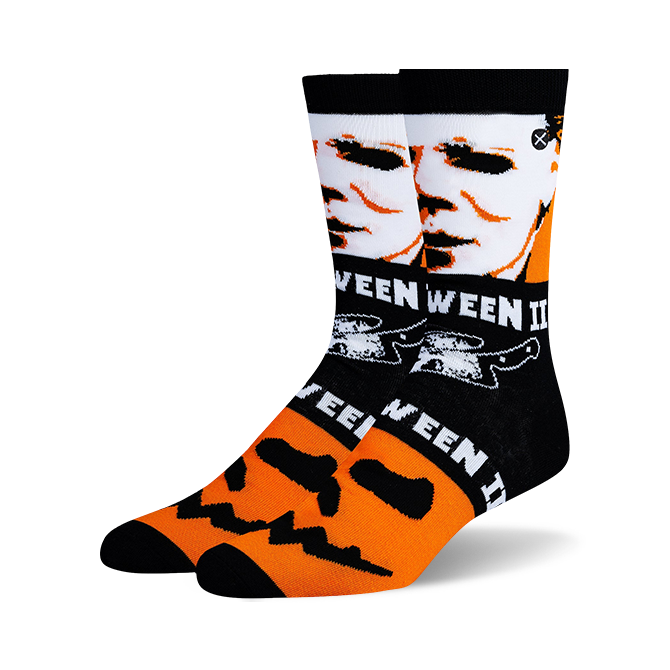 Pair of black crew socks with orange and white Halloween designs. Features Michael Myers' face and jack-o'-lantern faces.