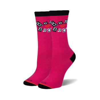 A pair of bright pink crew socks with black cuffs, heels, and toes. White squares with 'Burn Book' text and red lips are on the ankle.