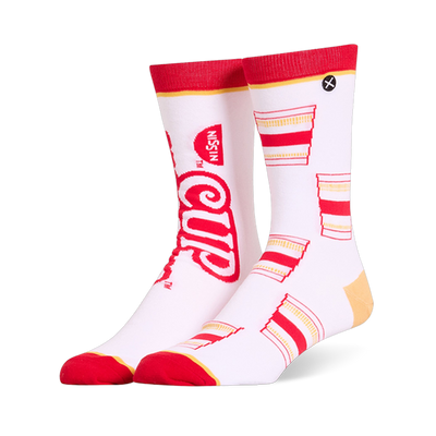 White crew socks featuring a mismatched design with a large red Cup Noodles logo on one and a pattern of cups on the other.