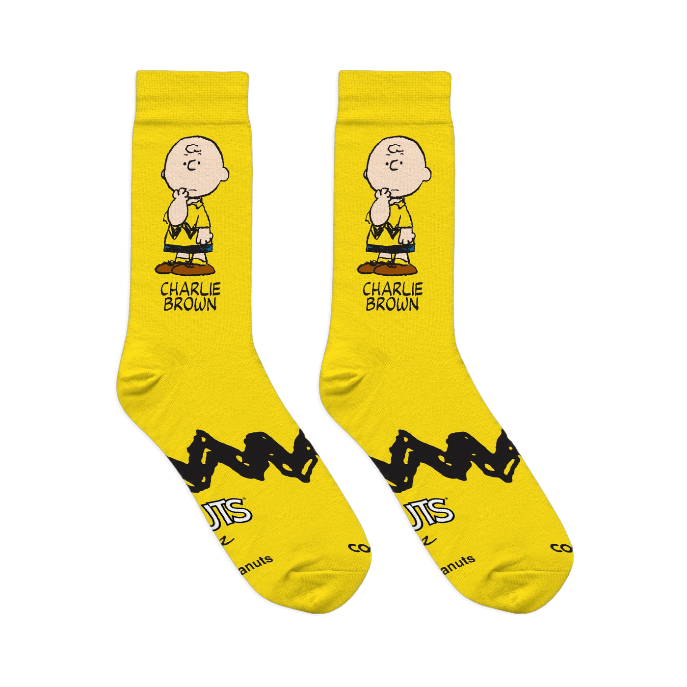 Flat lay of two bright yellow crew socks showing a Charlie Brown graphic, zigzag stripe, and Peanuts logo on the soles.