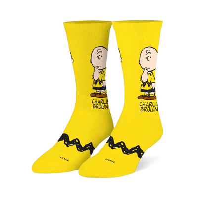 Bright yellow crew socks featuring a pensive Charlie Brown illustration on the leg and his signature black zigzag stripe.