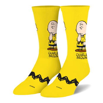 Bright yellow crew socks featuring a pensive Charlie Brown illustration on the leg and his signature black zigzag stripe.
