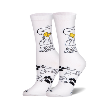 Pair of white crew socks showing Snoopy holding Woodstock, with black paw prints and star shapes on the ankle.