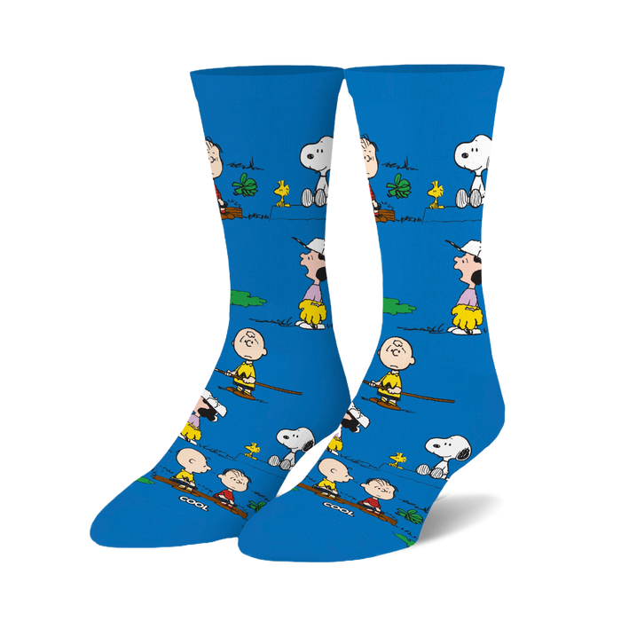 Crew socks in bright blue featuring Peanuts characters like Snoopy and Charlie Brown engaged in outdoor activities. 