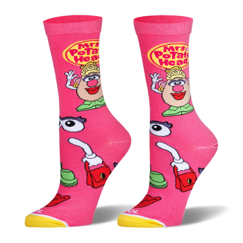 Bright pink socks featuring Mrs. Potato Head, a yellow logo, and scattered accessories like eyes, lips, and a red purse.