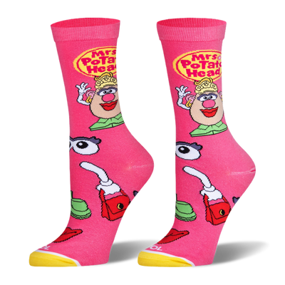 Bright pink socks featuring Mrs. Potato Head, a yellow logo, and scattered accessories like eyes, lips, and a red purse.