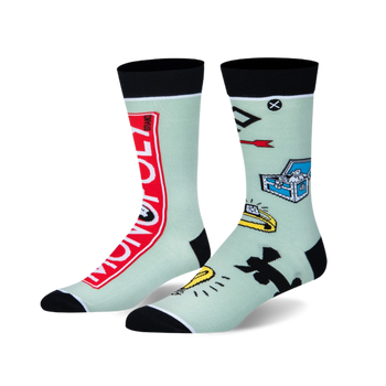 A pair of mint green crew socks. Left sock has a red Monopoly logo. Right sock has Monopoly game piece symbols. Black cuffs/toes.