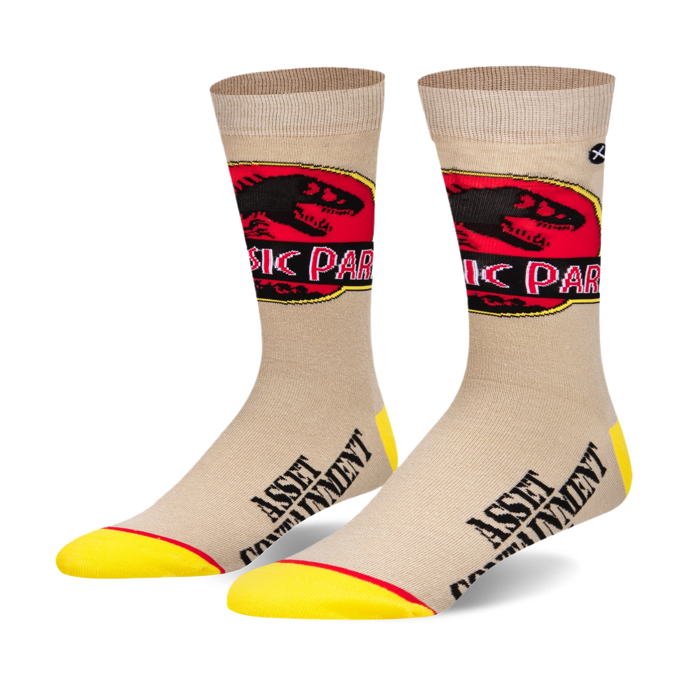 Pair of beige crew socks with a Jurassic Park logo and 'Asset Containment' text. Yellow accents at the toe and heel.