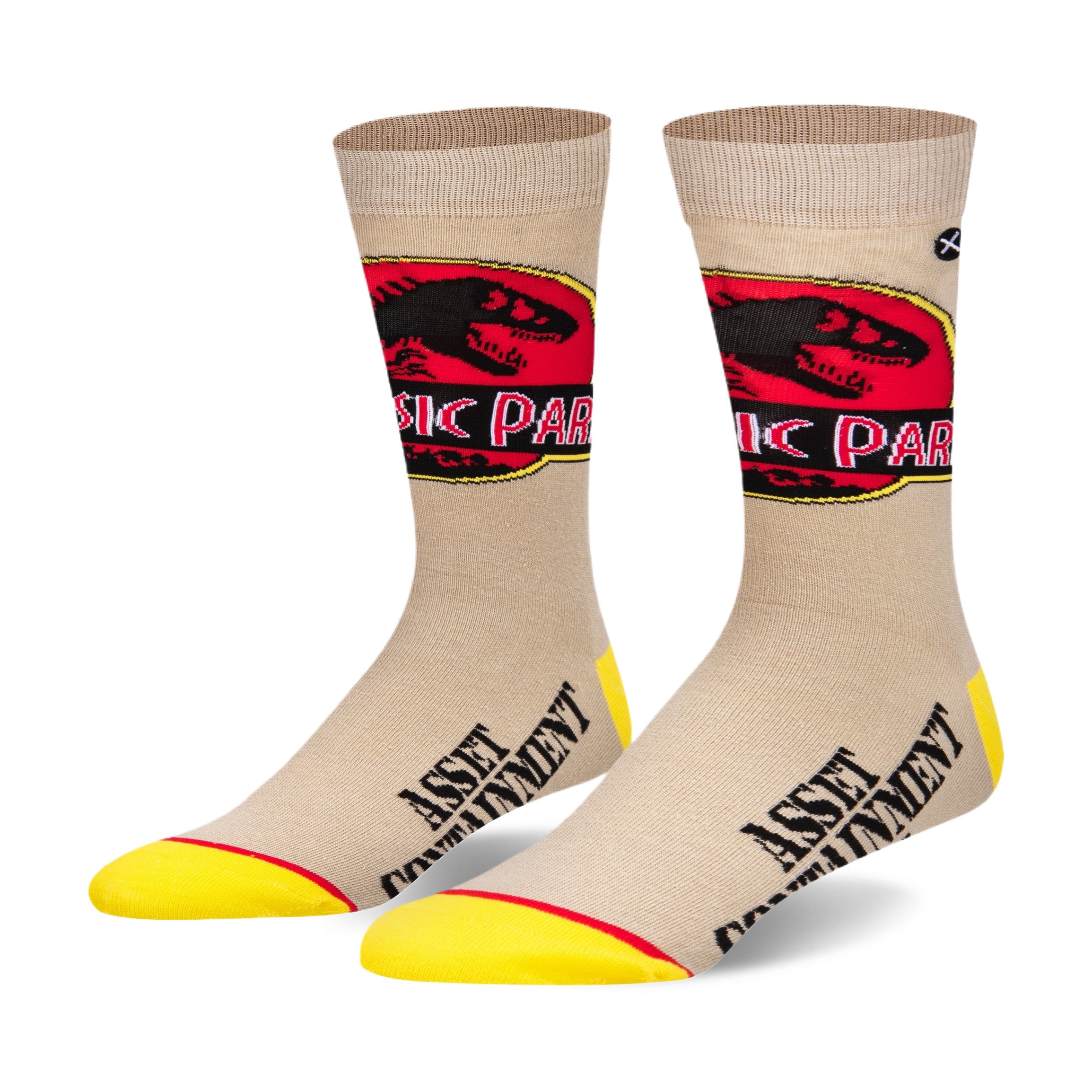 Pair of beige crew socks with a Jurassic Park logo and 'Asset Containment' text. Yellow accents at the toe and heel.