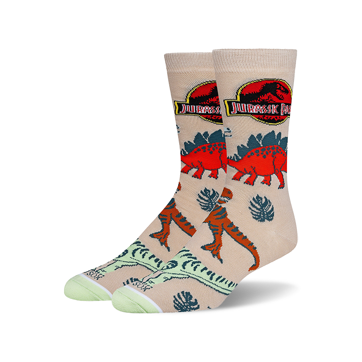 Tan crew socks with a Jurassic Park theme.  Features red and orange dinosaurs, tropical leaves, and the Jurassic Park logo.
