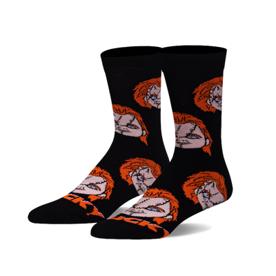 Pair of black crew socks with a repeating pattern of Chucky's doll head, featuring orange hair and stitched facial details.