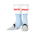 A pair of crew socks, predominantly light blue and white, feature the 'JAWS' title and a shark's mouth emerging from the water.