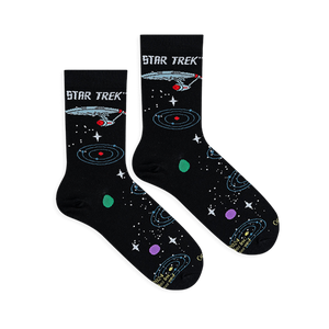 Flat lay of two black Star Trek socks showing the Enterprise ship and colorful orbiting planets.
