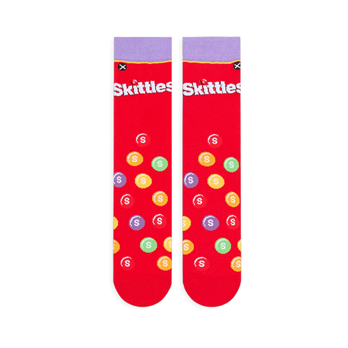 Flat lay of two red Skittles socks showing the light purple cuff, white logo, and scattered multi-colored candy pattern.